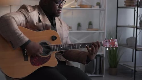 Man Plays Acoustic Guitar and Sings Indoors