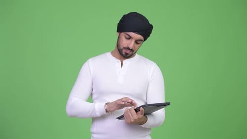 Man With Turban Using a Tablet