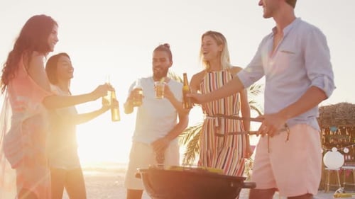 Friends Enjoying Beach Barbeque at Sunset