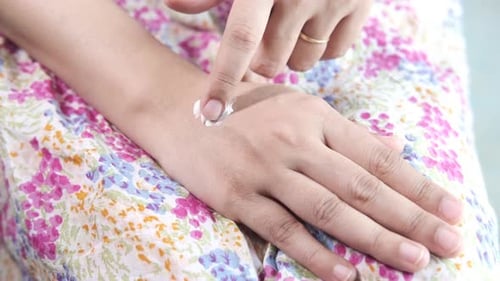 Woman Applying Beauty Cream Onto Skin at Home Top View