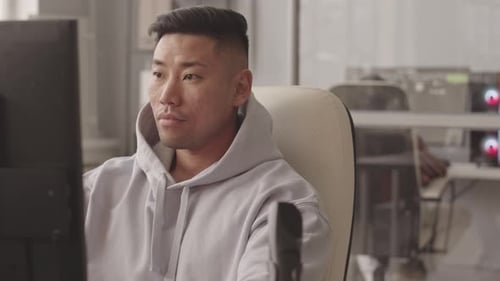 Focused Young Adult Working at Computer in Office