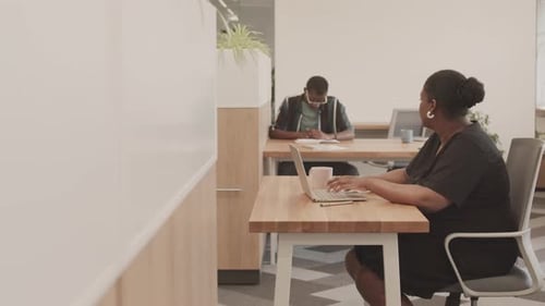 Femme afro-américaine tapant sur un ordinateur portable au bureau