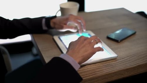 Businessman Works on a Tablet with Charts