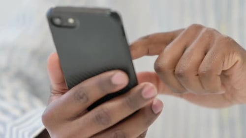 Close Up of African Man Using Smartphone Mobile