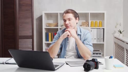 Workplace of freelance worker at home office. Young man works using computer.