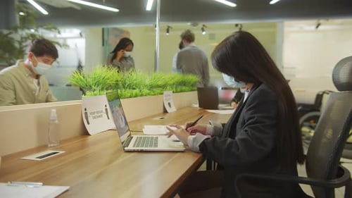 Office Workers in Masks Working at Desks
