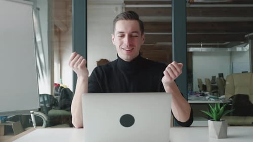 Smiling Businessman Using Laptop Computer for Video Conference While Sitting at Office
