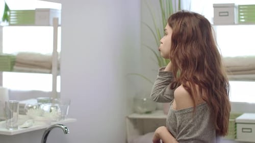 Woman Brushing Teeth in Bright Modern Bathroom