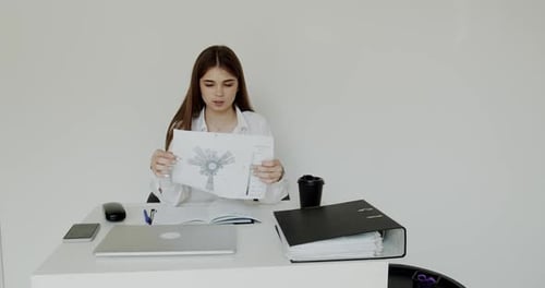 Young Girl Explaining the Topic at Camera at Workplace in Office