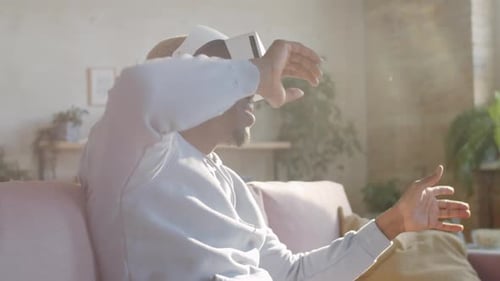 Man Using VR Headset on Couch in Living Room