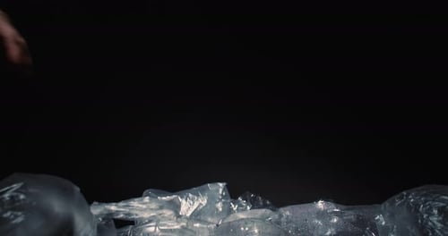 Hand Adds Plastic Waste to Pile