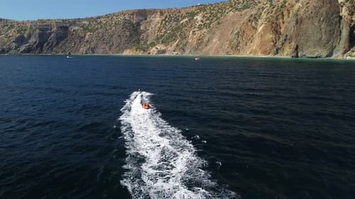 Jet Ski Pulling Raft on Ocean Coastline