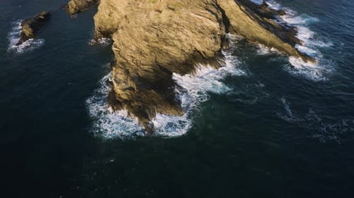 Fly over Sea Coast, waves crashing on Rocks. Aerial view of ocean