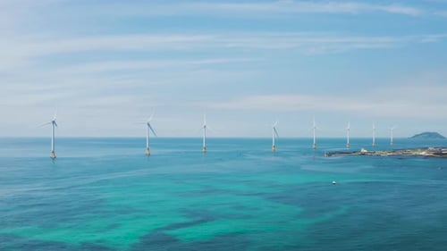 Wind turbines lined up over the sea. Sea and sky scenery. Jeju island.