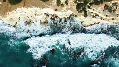 Aerial Top View Footage By Drone of Ocean Blue Waves Break on High Cliff of a Rocky Mountain