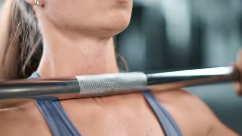 Blonde Woman Exercising With Barbell at the Gym