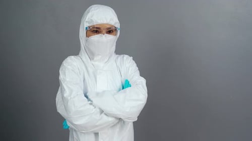 Person in Protective Suit and Mask Crosses Arms
