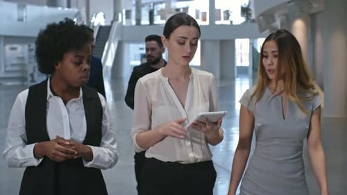 Business Women Walking and Talking in Modern Office