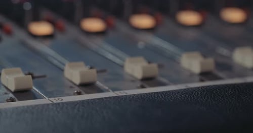 Sound engineer working in a recording studio with a sound console and microphones