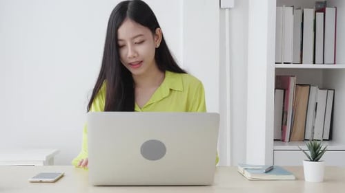Young asian businesswoman working on laptop computer on desk at home office.