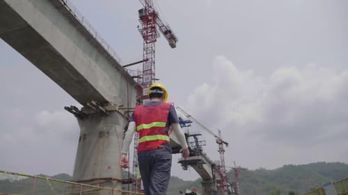 Ingénierie marche près du pont de construction traversant la rivière