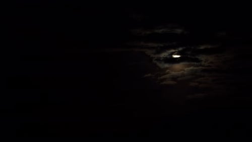 Moody Moon Lit by Clouds in Dark Night Sky