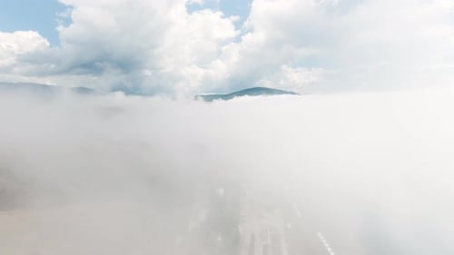 Top View of Dense Clouds in Sky with Mountain Peaks