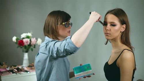 Makeup Artist Applying Makeup to a Young Woman