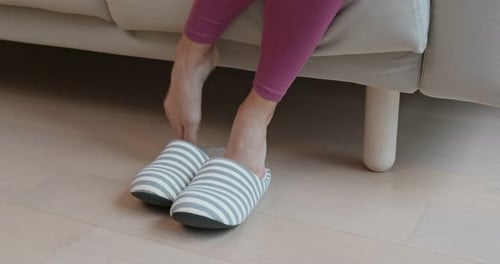 Une femme porte des pantoufles à la maison