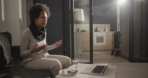 Woman on Laptop Video Call with Pills