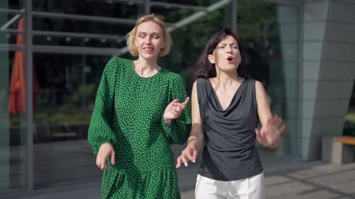 Joyful Women Dancing Walking on City Street in Slow Motion Singing