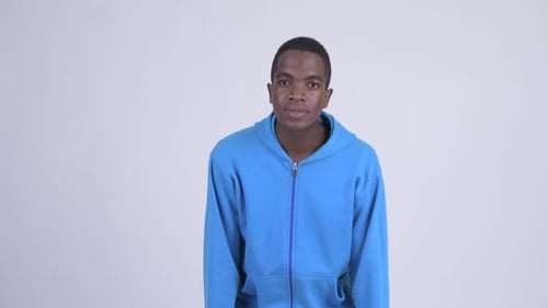 Young Man Surprised, Hands Over Mouth in Studio