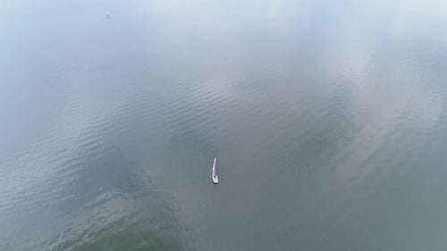 Luftbild eines Windsurfers, der auf dem Wasser segelt