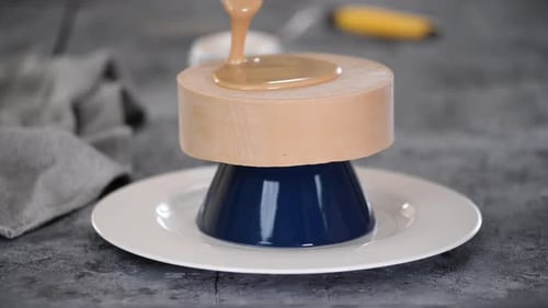 Pouring Delicious Brown Glaze on Wooden Cake