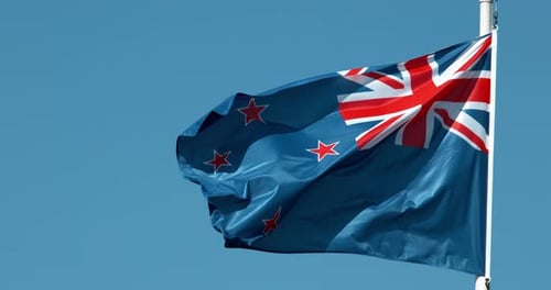 New Zealand Flag Waving Against Blue Sky