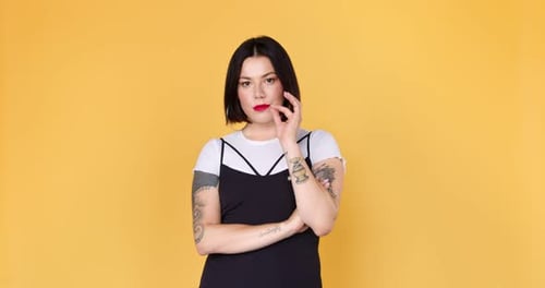 Stylish Woman Posing in Front of Yellow Backdrop