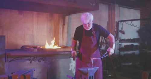 Blacksmith Forging Hot Metal in Dark Workshop