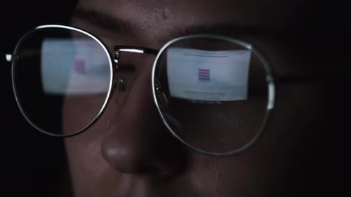 Young Adult with Screen Reflection on Glasses