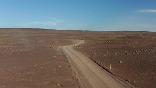 Drone Following Car Driving in Rock Desert in Isolated Volcanic Iceland