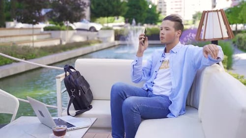 Young Adult Working on Laptop by Urban Fountain