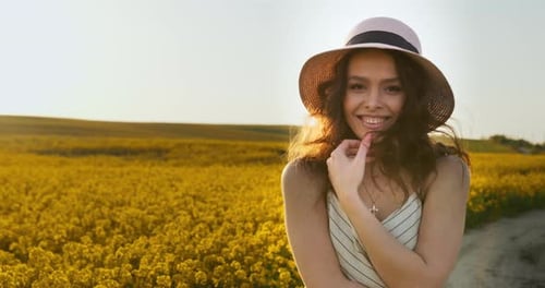 Smiling Woman in Straw Hat in Flower Field