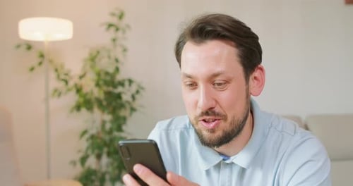 Man Using Phone for Video Call at Home