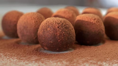 Close Up of Homemade Raw Vegan Energy Balls with Cocoa Powder Lying in a Row