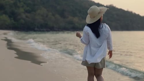 Portrait of happy smiling Asian female walking on the beach beautiful sunset.