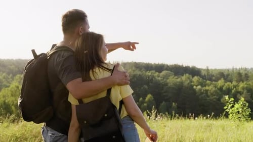 Happy Couple Enjoying Hike Together with Backpacks Hugging Back View