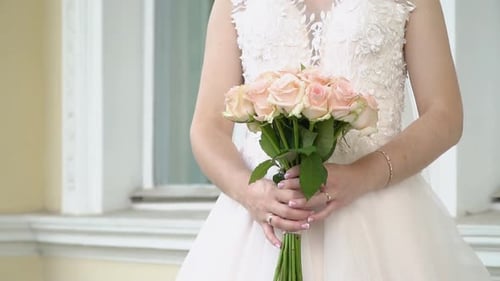 Bride in White Holding Peach Rose Bouquet