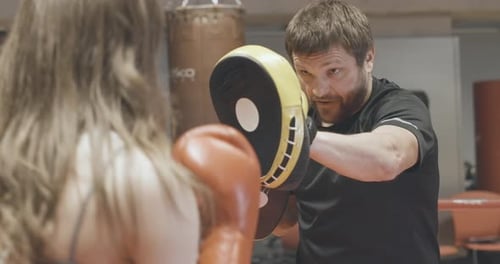 Woman Boxing with Trainer in Urban Gym