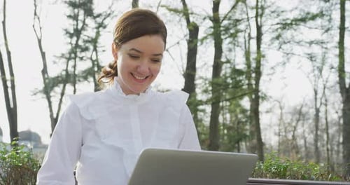 Woman with laptop in the park