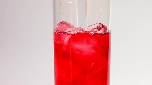 Ice and Red Drink Poured in Glass