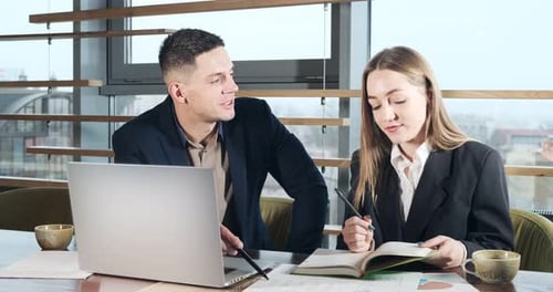 Man and a Woman Discussing Work in the Brightly Lit Modern Office. Concerned Male and Female Working
